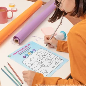 A girl is drawing in a fill colors by number book placed on a round table surrounded by pencils, notes, charts, tapes, a mug, and a sharpener.